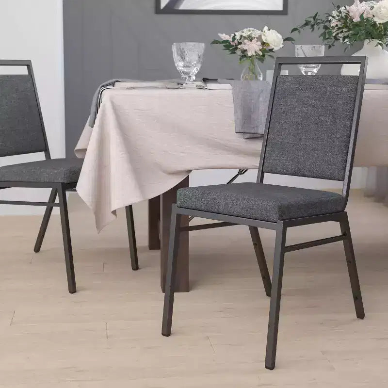 Chaise de banquet empilable avec dossier carré et cadre nervuré argenté.
